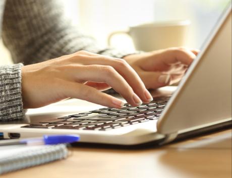Persoon typt een Word CV op een laptop en werkt aan een professioneel cv in Microsoft Word.